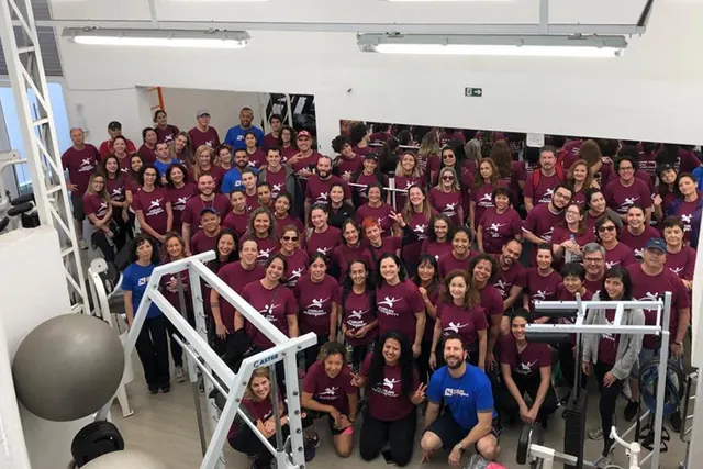 Dezenas de alunos com a camiseta roxa da Nova Imagem reunidos na academia
